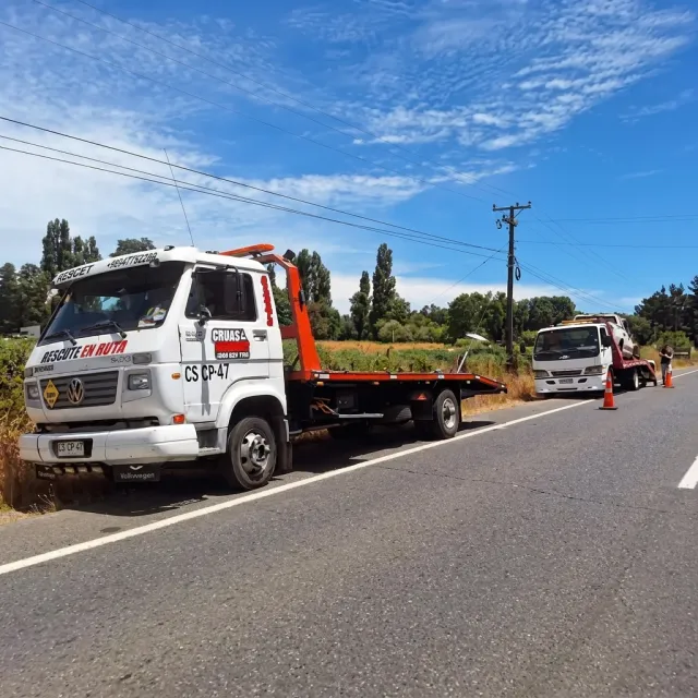 Dos grúas trabajando juntas en la carretera, a las afueras de Villarrica.