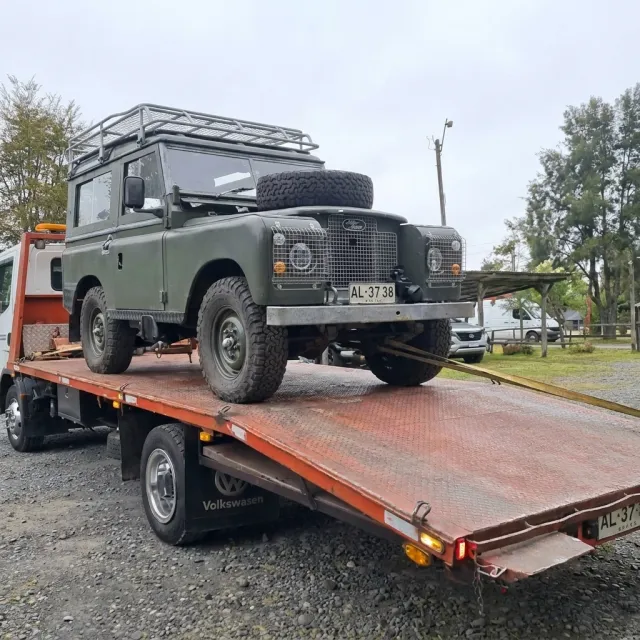 Grúa llegando al centro de Villarrica con un jeep sobre la plataforma.
